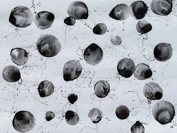 Black bubbles, circles and splashes. Black and white background. BW. Spray