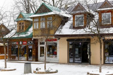 Zakopane, Polonya - 19 Mart 2018: Krupowki Street tarihleri yaklaşık 1905 ve orada zemin katta ahşap binaya mağaza pencerelerdir. Ağaçlarda yaprakları vardır, kış.