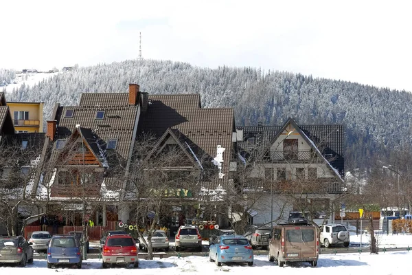 Zakopane, Polonya - 21 Mart 2018: bir kaç konut ev Gubalowka olarak adlandırılan bir tepenin arka planı görülebilir. Birkaç araba yerel otoparkında park yerleri park