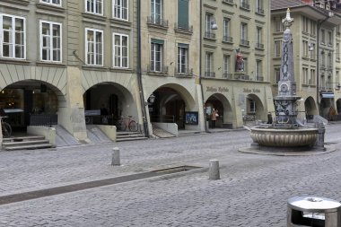 Bern İsviçre - 19 Şubat 2018: Oval taş çeşme ve onun merkezi tarihleri geri 1778 yılında yüksek bir dikilitaş. Kreuzgass Çeşme Old Town ana caddede yer alan.