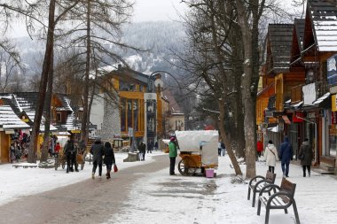 Zakopane, Polonya - 19 Mart 2018: Birkaç kişi Krupowki boyunca sokakta yürüyorum. Caddenin her iki tarafında orada binalar ve hangi genellikle yerel peynirler satılır yolda küçük bir ahır.