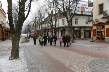 Zakopane, Polonya - 17 Mart 2018: İnsanlar sokakta yürüyorum. Bu da bu şehrin ünlü alışveriş bölgesi olan ana gezinti boyunca görülür. 