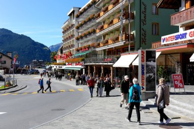 Grindelwald, İsviçre - 21 Eylül 2017: turizm köyde yabancı yönergeleri izleyin birçok kişi vardır. Orada da evleri, oteller ve uzaktan tepeler vardır.