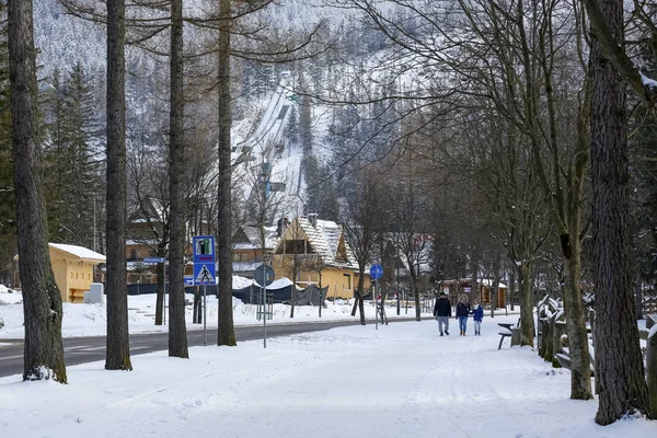 ザコパネ ポーランド 2018 遊歩道は雪とそれを歩いている人で覆われています そこに 山の斜面にことがわかりますスキー ジャンプ複合体 — ストック写真