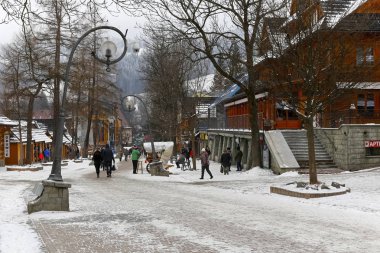 Zakopane, Polonya - 19 Mart 2018: Bu mesire Krupowki sokak adı verilen bir ünlü alışveriş alandır. Çünkü bu kış karla kaplı bir kaldırım yürüyüş insanlar.