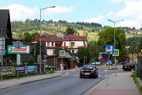 Zakopane, Polonya - 15 Ağustos 2017: Bir sokak görüntülemek küçük trafik ile orada sadece birkaç araba ve bir kaç kişi. Orada yol işaretleri ve uzak Hill'de güneş tarafından aydınlatılmış.