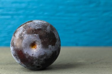 Renkli ahşap arka plan üzerine düzenlenmiş bir bütün taze erik