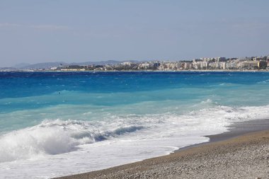 Fırtınalı dalgalar deniz kıyısı, Nice, Fransa güneşli ama rüzgarlı bir günde görülmektedir.