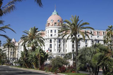 Fransa - 25 Eylül 2018: The Negresco Hotel Akdeniz ve Promenade des Anglais üzerinde palmiye ağaçları arasında görülür bakan.