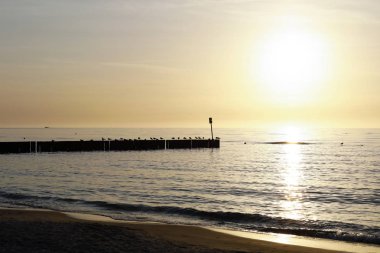 Baltık Denizi üzerinden günbatımı sırasında sahil