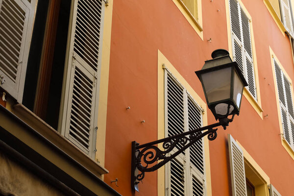 Metal bracket with a street lamp installed on the facade of the building in the old town of Nice, which is an important city of the French Riviera.