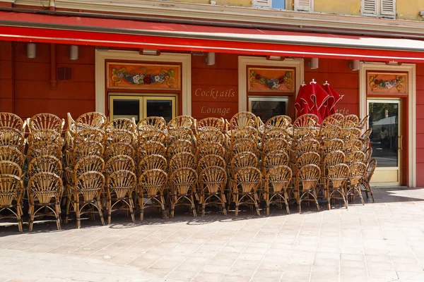 Wooden chairs are placed outside red building — Stock Photo, Image