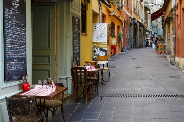 一条狭窄的街道上有三张桌子 — 图库照片