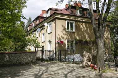 Çitin arkasında bir ev var.