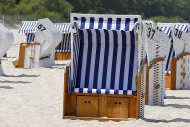 Çatılı hasır plaj sandalyeleri bir plajda