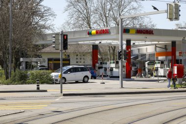 Tramvay raylarının arkasında bir benzin istasyonu var.