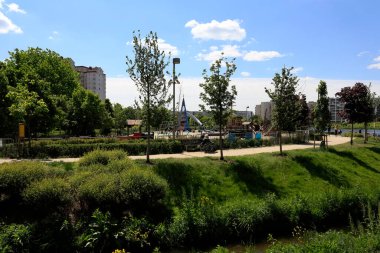 Varşova, Polonya - 22 Mayıs 2020: yemyeşil bitki örtüsü arasında dar bir kaldırım var. Burası Goclaw konutlarında görülebilen park alanları..