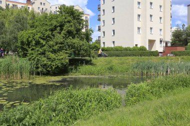 Varşova, Polonya - 2 Haziran 2020: Göl kenarındaki meskun bina Goclaw konutlarında görülebilen park alanlarında görülebilir..