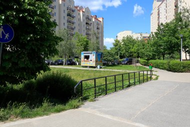 Varşova, Polonya - 2 Haziran 2020: Goclaw konutlarındaki çoklu aile konutlarının oluşturduğu küçük bir köprü. Etrafta bir sürü yemyeşil bitki var..