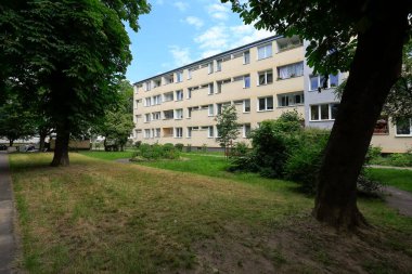 Varşova, Polonya - 16 Haziran 2020: Saska Kepa bölgesindeki çimenlerin ve ağaçların arkasındaki apartman çok sayıda evin birbirine yakın olduğu bir bölgedir..