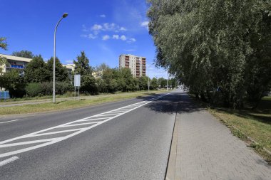 Varşova, Polonya - 05 Ağustos 2020: Ağaçlar arasında bir şehir caddesi var, pek çok apartman sakininin görebileceği şekilde. Şehrin bu kısmına Goclaw konutları denir..