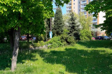 Varşova, Polonya - 10 Mayıs 2020: bereketli bitki örtüsü arasında Goclaw konutları. Burada aynı zamanda Meryem Ana 'nın bir heykelini görebilirsiniz, yemyeşil bitkilerle çevrili..