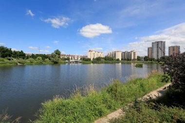 Varşova, Polonya - 05 Ağustos 2020: Goclaw adlı konut arazisindeki apartman binaları park alanının bir parçası olan büyük bir göl yakınında yer almaktadır..