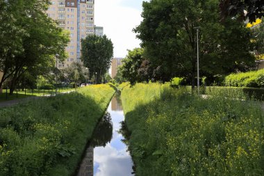 Varşova 'da Goclaw adında bir konutta görülen dar bir kanal tarafından yemyeşil bir bitki örtüsü..