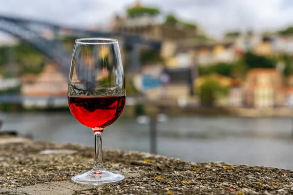 Sklenku portského vína s rozmazané panoráma města Porto Portugalsko v pozadí — Stock fotografie