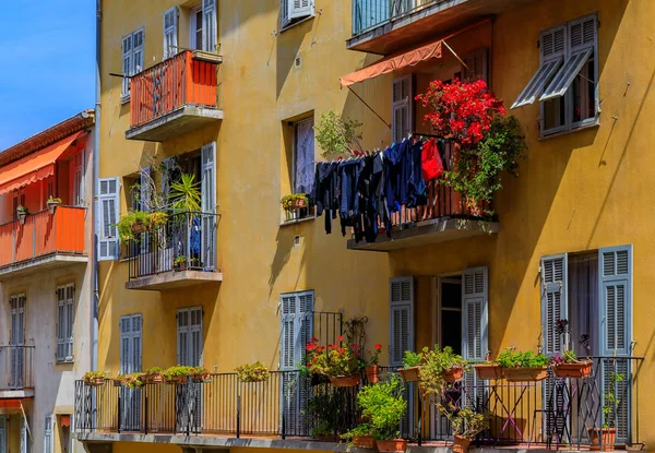 View of traditional mediterranean houses with flowers and laundry drying outside in the streets Old Town of Nice, France
