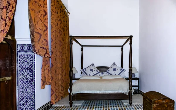 stock image Traditional Moroccan bedroom with a canopy bed, mosaic and drapes in riad in Fes, Morocco