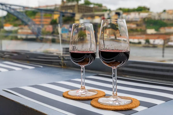 Glass of port wine with the blurred cityscape of Porto Portugal in the background