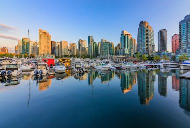 04 Ağustos 2018 - Vancouver, Kanada: Kömür Limanı Şehir Merkezi Binası, tekneler ve su yansımalar olan günbatımında