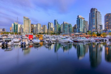 04 Ağustos 2018 - Vancouver, Kanada: Kömür Limanı Şehir Merkezi Binası, tekneler ve su yansımalar olan günbatımında