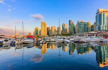 04 Ağustos 2018 - Vancouver, Kanada: Kömür Limanı Şehir Merkezi Binası, tekneler ve su yansımalar olan günbatımında