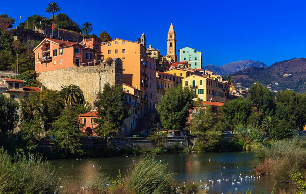 Colorful old buildings perched atop a hill in the medieval town of Vintimiglia in Italy, just across from the French border