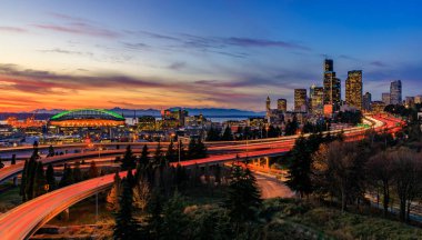 Seattle şehir manzarası ile uzun pozlama trafik iz ışıkları Dr Jose Rizal veya 12 Avenue South Bridge gün batımında I-5 I-90 çevre yolu Kavşağı ötesinde Panoraması