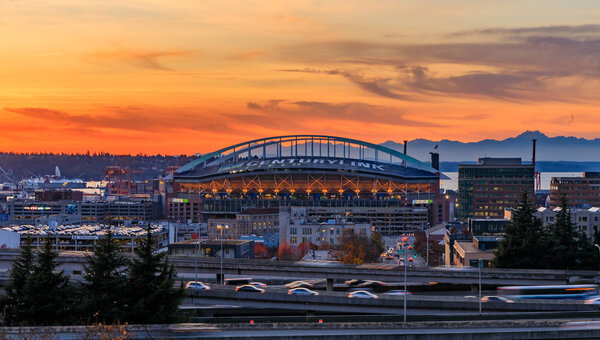 Seattle downtown and Safeco Field  beyond the I-5 I-90 freeway interchange at sunset in the fall with yellow foliage in the foreground view from Dr. Jose Rizal or 12th Avenue South Bridge