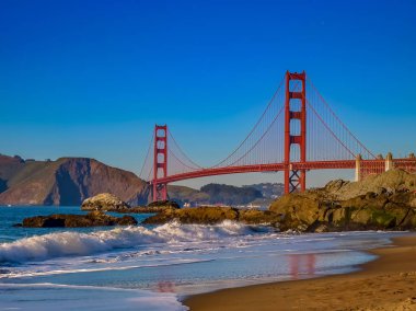 İnişli çıkışlı dalgalar bir gün batımından önce Baker Sahili üzerinde Golden Gate Köprüsü