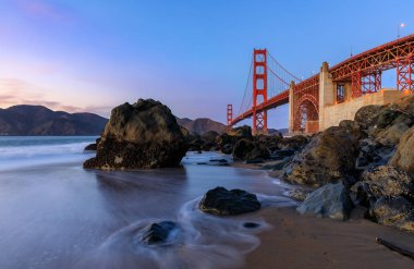 Ünlü Golden Gate Köprüsü görünümden gizli ve tenha kayalık Marshall'ın Beach gün batımında San Francisco, California