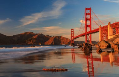 Ünlü Golden Gate Köprüsü görünümden gizli ve tenha kayalık Marshall'ın Beach gün batımında San Francisco, California