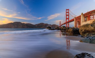 Ünlü Golden Gate Köprüsü görünümden gizli ve tenha kayalık Marshall'ın Beach gün batımında San Francisco, California