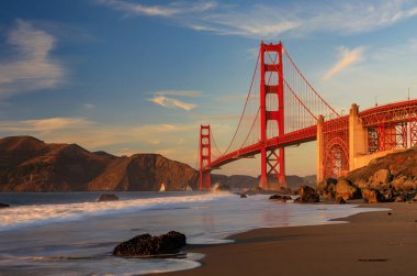 Ünlü Golden Gate Köprüsü görünümden gizli ve tenha kayalık Marshall'ın Beach gün batımında San Francisco, California