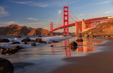 Ünlü Golden Gate Köprüsü görünümden gizli ve tenha kayalık Marshall'ın Beach gün batımında San Francisco, California