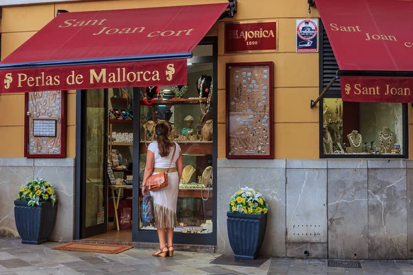 Bir mücevher dükkanı İspanya Mallorca'da Palma de Mallorca'da sergilenen inci takı, arayan genç bir kadın Mallorca inciler için ünlüdür
