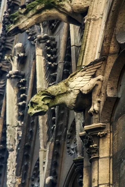 Gothic gargoyles covered in moss on the facade of the famous Notre Dame de Paris Cathedral in Paris France