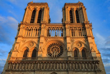 Notre Dame de Paris Katedrali cephesi en eski gül pencere ve günbatımı sıcak ışığıyla renkli süslü oyma ile Güney cephe detayları
