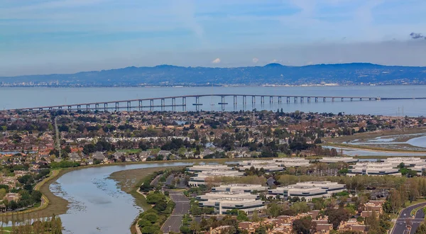 Luftaufnahme der San Mateo Heuwarenbrücke über die San Francisco Bay und Pflegestadt im San Mateo County, Kalifornien lizenzfreie Stockfotos