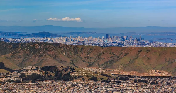旧金山市中心和金融区摩天大楼的鸟图在南旧金山上空飞行在大约很快圣布鲁诺山上的工业城市铭文 — 图库照片
