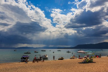 Carnelian Bay, Califronia ABD - 19 Temmuz 2015: turist rahatlatıcı plaj ve Botları suya Lake Tahoe suyun üstünde gördüm yapraklara